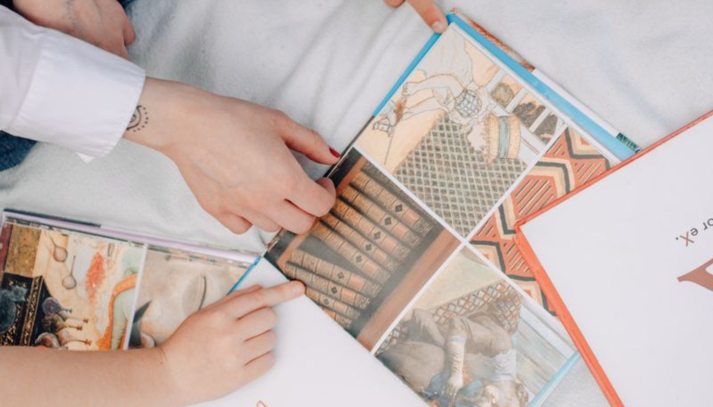 Illustrative close-up of hands exploring a picture book